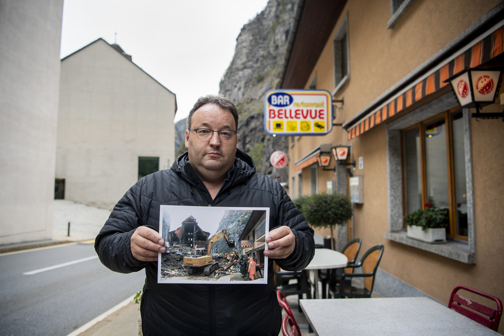 Roland Squaratti, le président de la commune, pose avec une photo prise par Laurent Gillieron datant de la catastrophe.