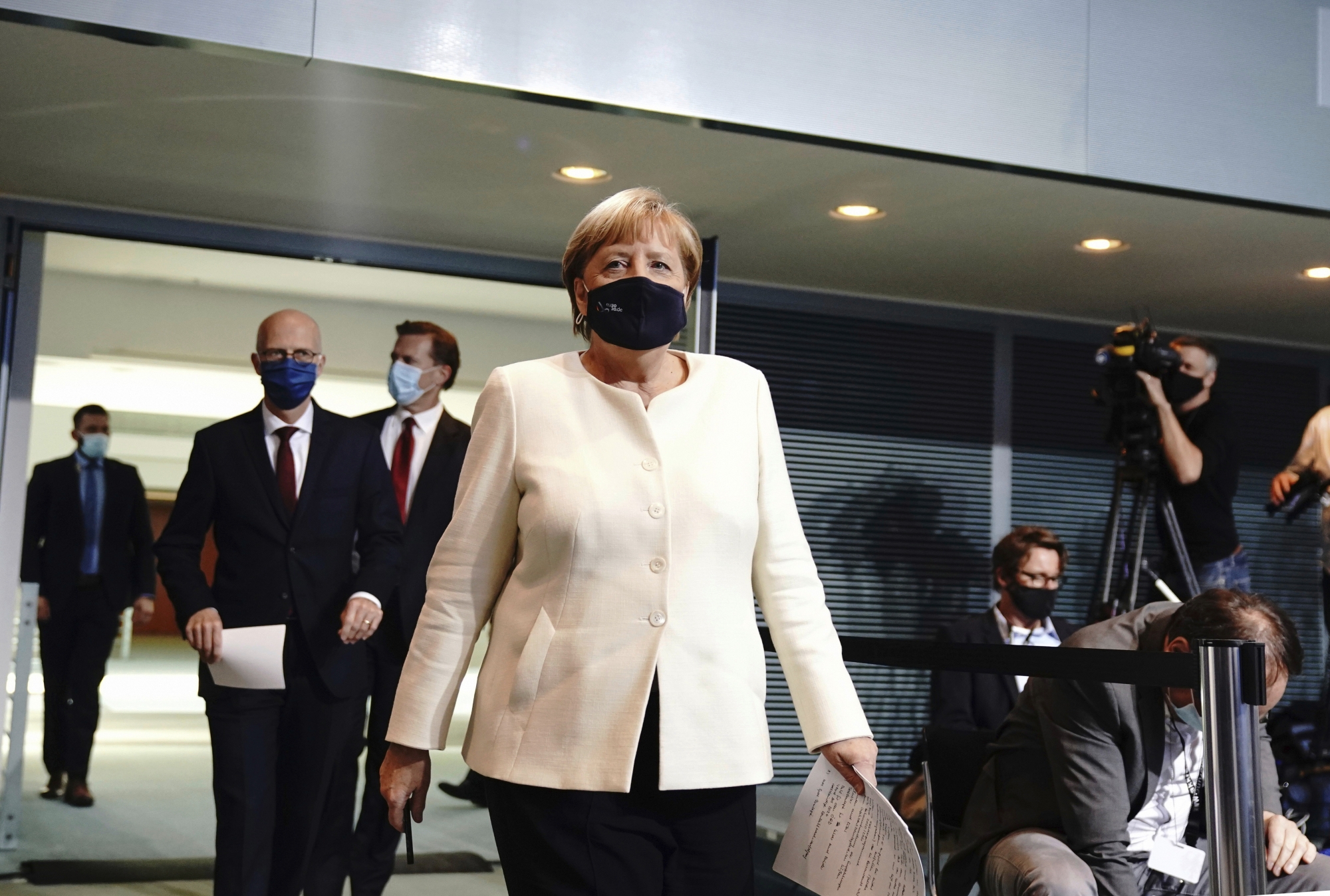 German Chancellor Angela Merkel, foreground arrives for a  coronavirus press conference, in Berlin, Tuesday, Sept. 29, 2020. Chancellor Angela Merkel and the governors of GermanyÄôs 16 states conferred on how to prevent the countryÄôs coronavirus infection figures from accelerating to the levels being seen in other European countries. (Kay Nietfeld/dpa via AP) ArcInfo