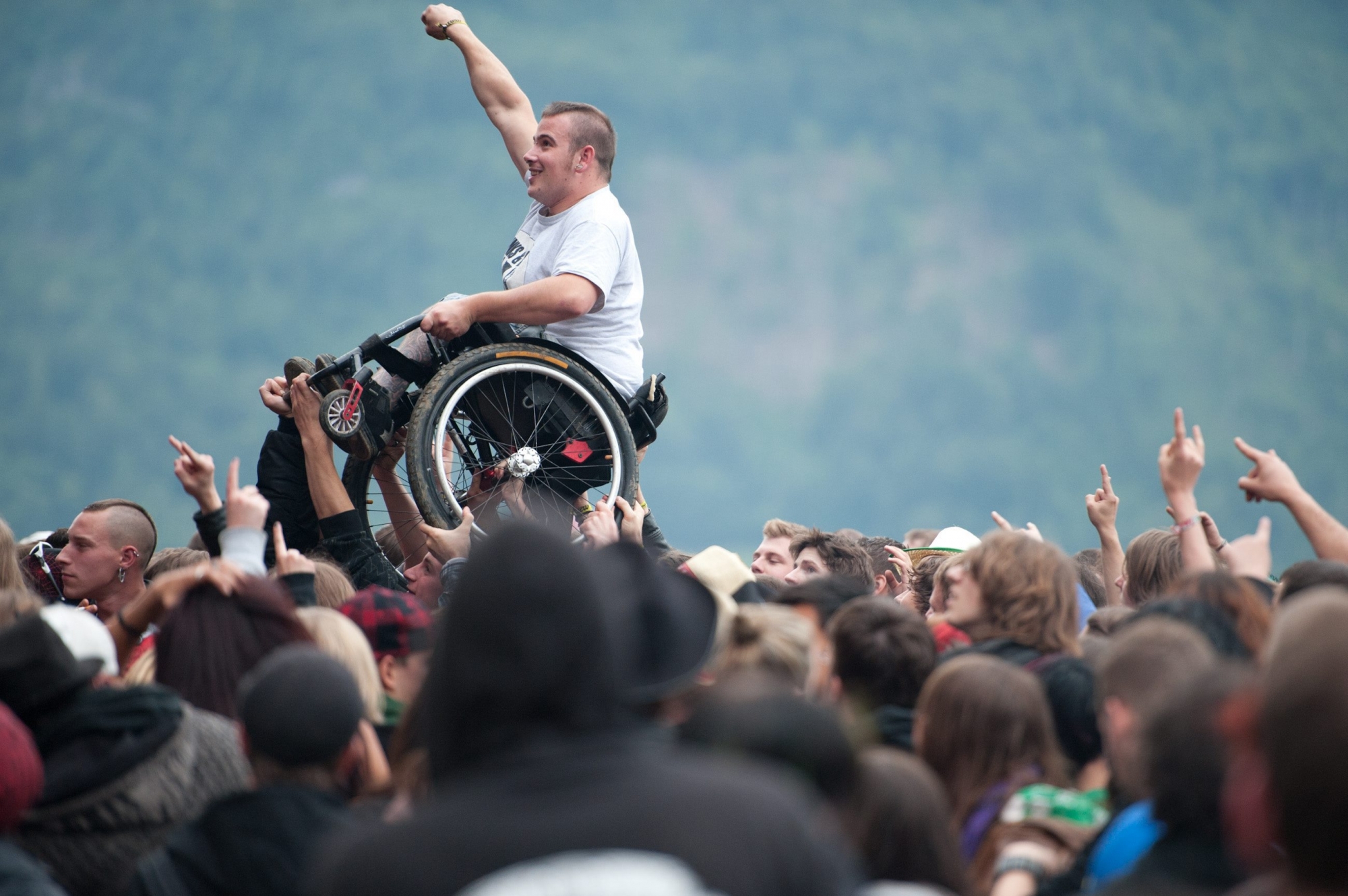 Ein Festivalbesucher im Rollstuhl wird von der Menschenmasse waehrend des Konzerts der Band "Flogging Molly" getragen, am Donnerstag, 9. Juni 2011, am Greenfield Festival in Interlaken. (KEYSTONE/Samuel Truempy)