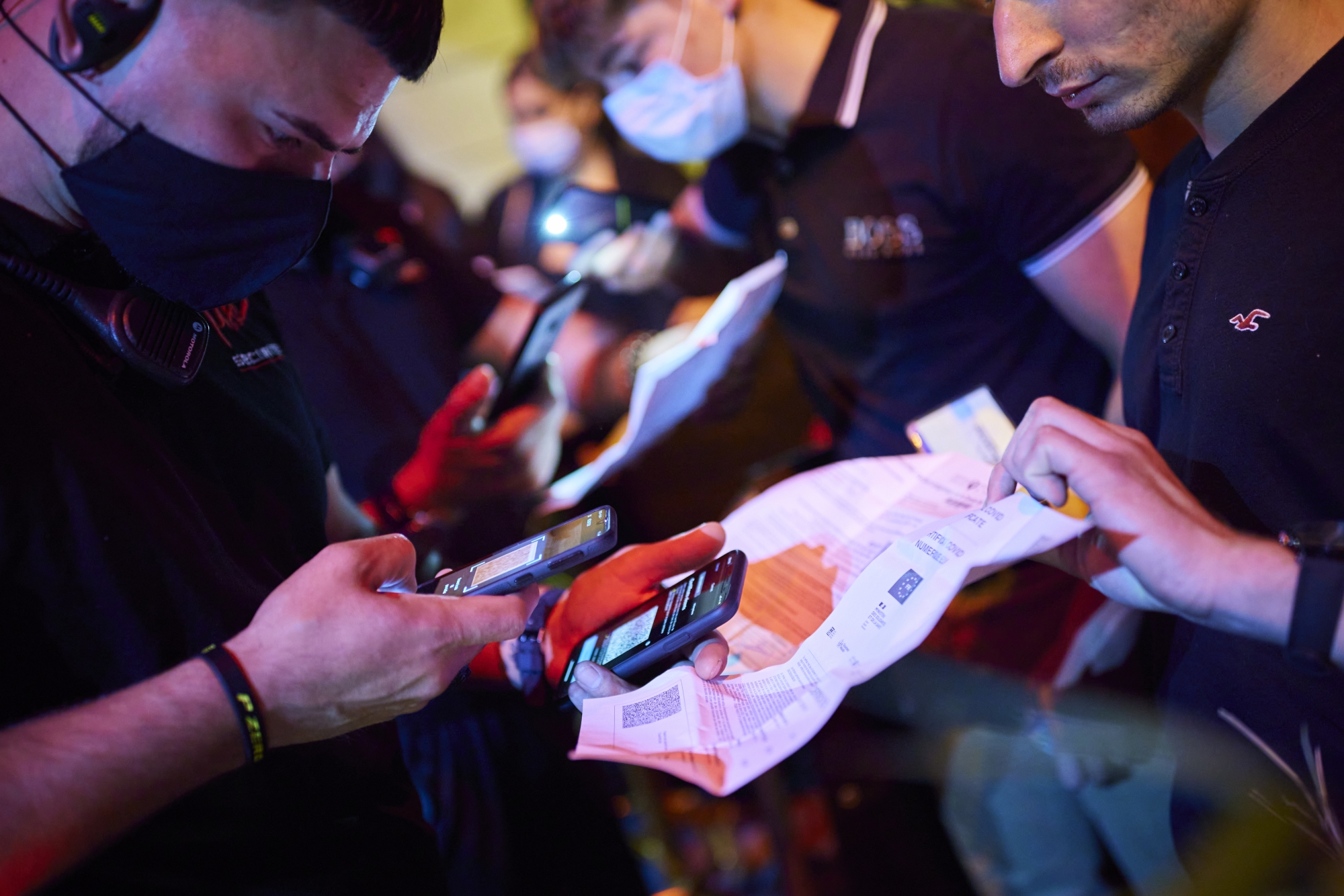 A security staff of the MAD (Moulin a Danse) night club scans the QR code of a COVID-19 certificate allowing entry in newly reopened nightclubs in Lausanne, Switzerland, late Friday, June 25, 2021. (KEYSTONE/Valentin Flauraud)