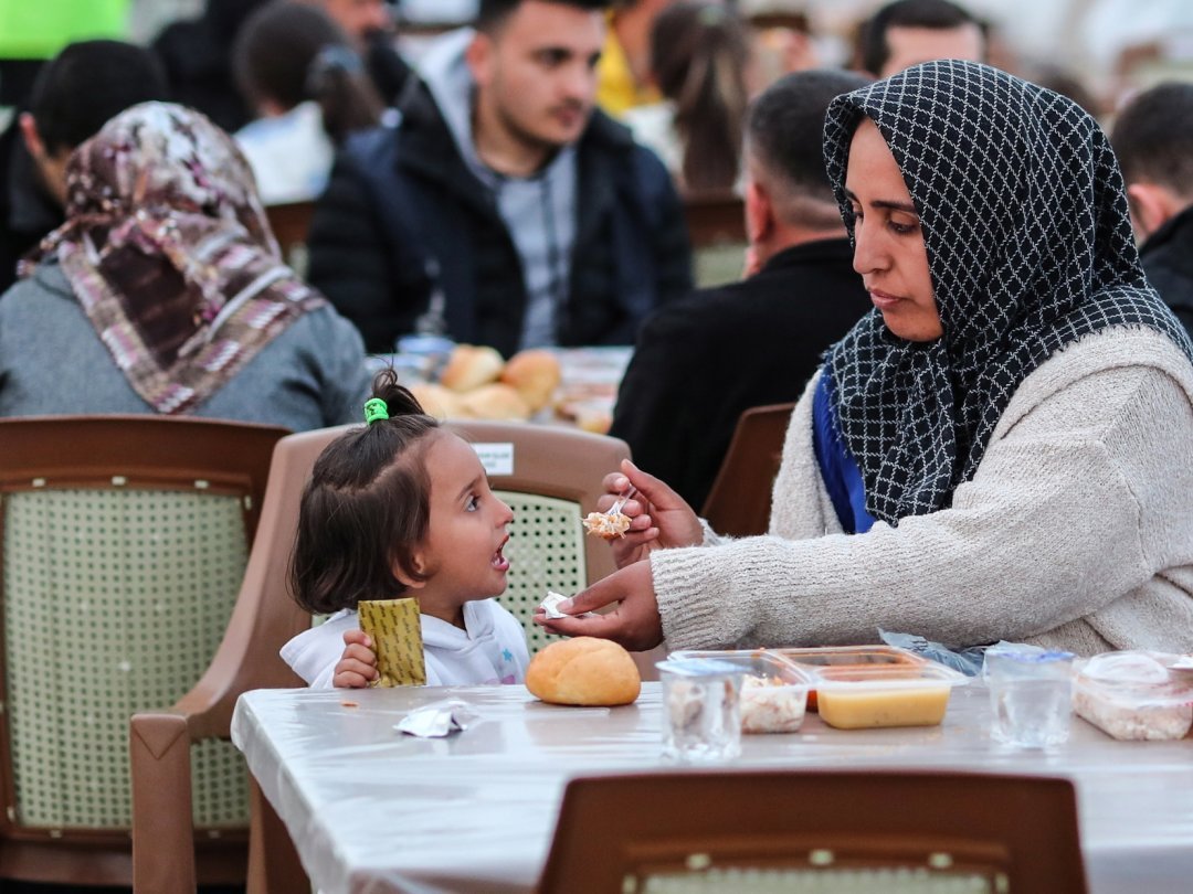 Avant de rompre le jeûne du Ramadan, cette mère nourrit sa fille. Adiyaman, Turquie, le 23 mars 2023.