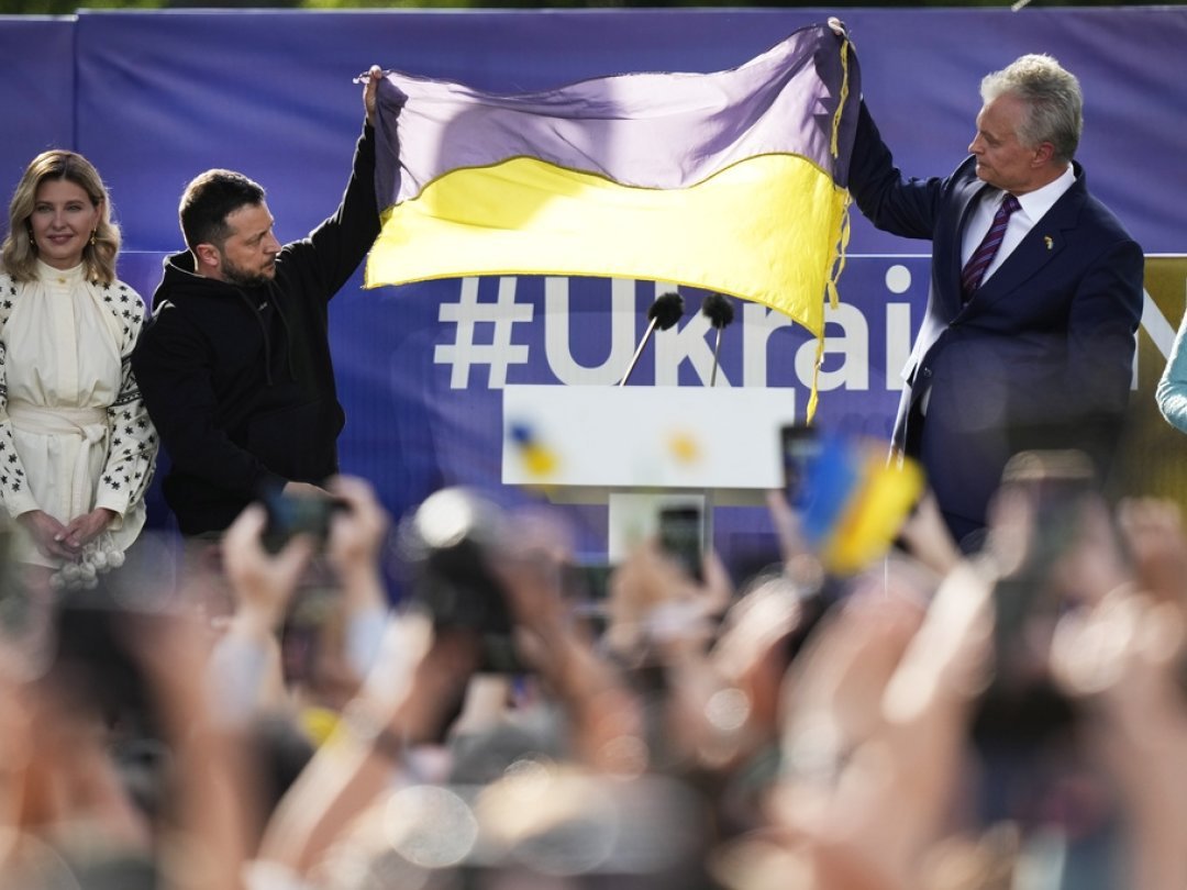 Volodymyr Zelenskyy et le président lituanien Gitanas Nauseda brandissent un drapeau ukrainien alors qu'ils s'adressent à la foule à Vilnius.
