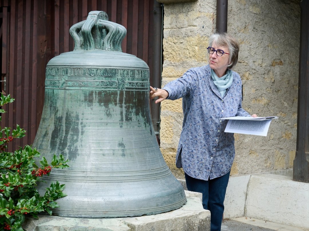 La campanologue Fabienne Hoffmann présente les détails de la décoration de l'ancienne cloche du temple de Corcelles.