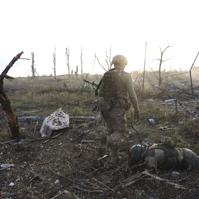 Un commandant de la 3ème brigade d'assaut ukrainienne "Azov" et la dépouille d'un soldat russe sur le front à Andriivka, dans le Donetsk, le 16 septembre.