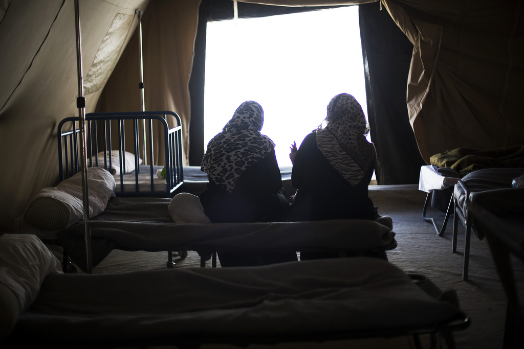 In this Thursday, Oct. 24, 2013 photo, Syrian women are seen within a tent of the Morocco Royal Army campaign hospital at the Zaatari refugee camp near the Syrian border in Jordan. The camp has three schools, two hospitals and a maternity clinic. (AP Photo/Manu Brabo)