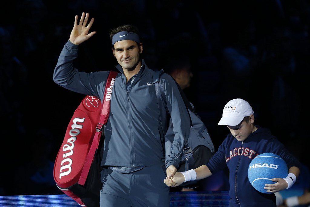 Roger Federer of Switzerland waves as he arrives at the court to play Novak Djokovic of Serbia during their ATP World Tour Finals double tennis match at the O2 Arena in London Tuesday, Nov. 5, 2013. (AP Photo/Sang Tan)