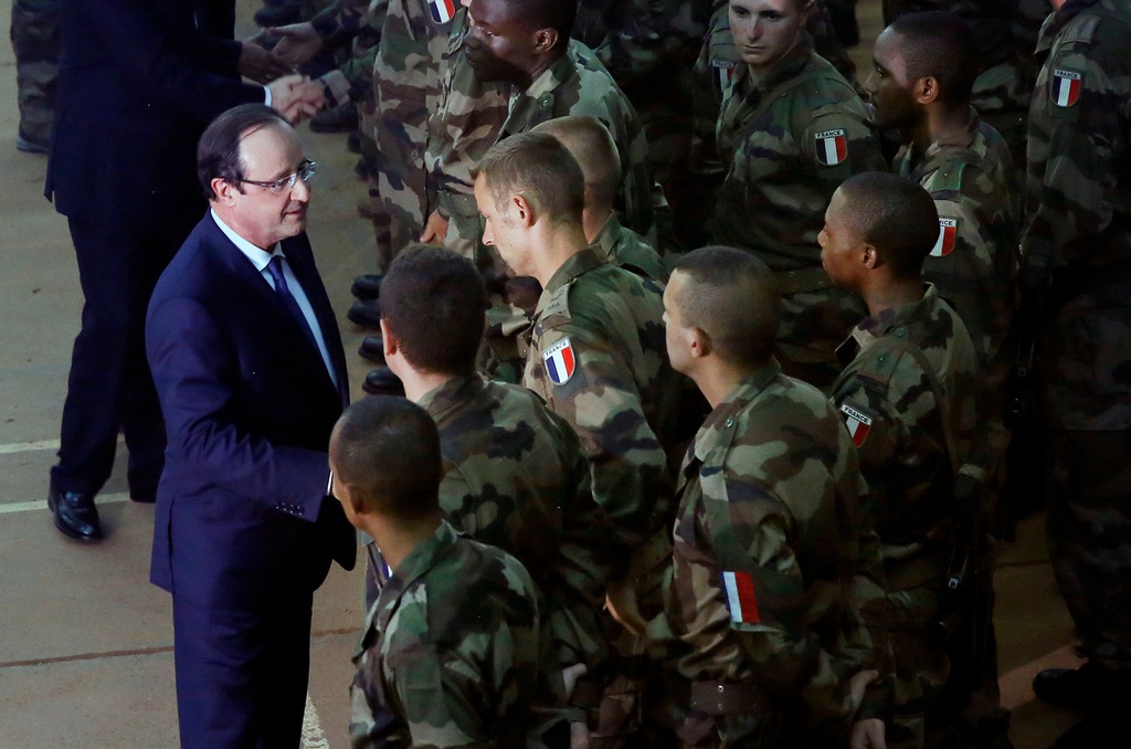 French President Francois Hollande, left,  addresses the troops during a stopover from South Africa in Bangui, Central African Republic, Tuesday  Dec. 10, 2013. Two French soldiers were killed in combat overnight since France stepped up its presence to restive the former French colony to help quell inter-religious violence.  (AP Photo/Jerome Delay)