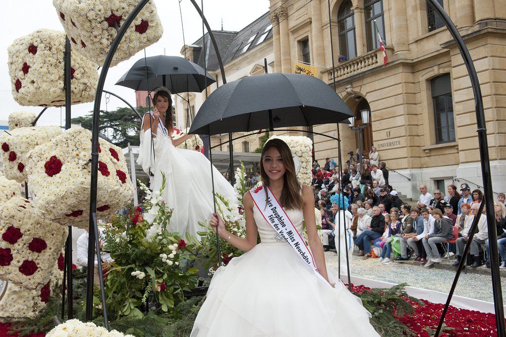 Gioya Bonanno, gauche, Miss Fête des vendanges 2013, assise sur un char lors du defile du celebre corso fleuri de la 88e edition de la Fête des vendanges de Neuchatel.