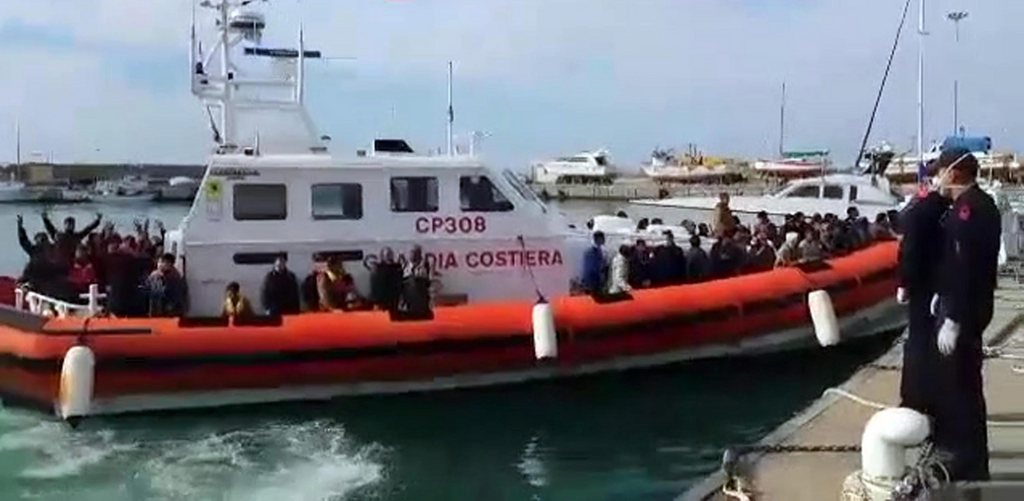 epa04160216 A handout video grabbed image made available by the Italian Coast Guard on 09 April 2014 shows the arrival in the port of Pozzallo (Sicily) of migrants rescued in the Strait of Sicily. The Italian authorities have rescued around 4,000 migrants over the past 48 hours, Italian Interior Minister Angelino Alfano said early on 09 April. The minister added that at least one person had been found dead aboard one of the multitude of rescued boats. Late 08 April 2014, Alfano organized a meeting with police, Navy and coast guard officials participating in the rescue-and-surveillance Mare Nostrum operation to deal with the emergency caused by a upswing in mass migrant arrivals in recent days.  EPA/ITALIAN COAST GUARD PRESS OFFICE HANDOUT  HANDOUT EDITORIAL USE ONLY/NO SALES