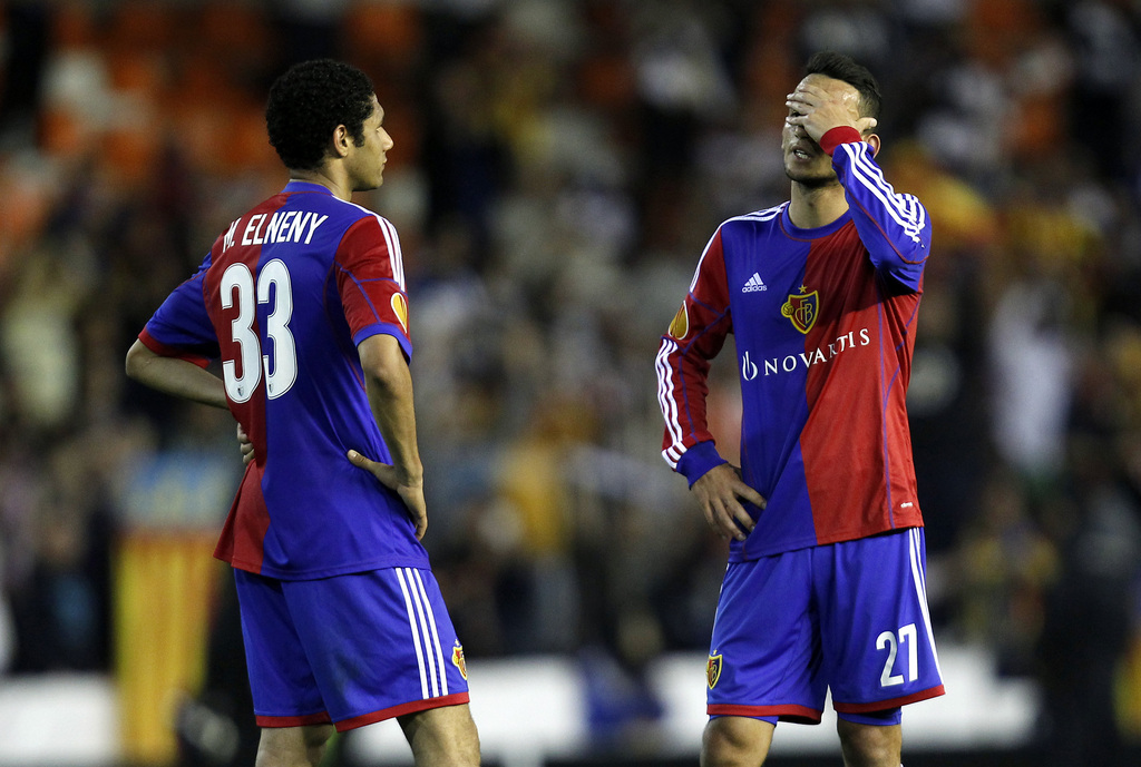Basel's Naser Aliji from Fyrom, right, and Mohamed Elneny from Egypt after losing to Valencia in the Europa League quarterfinal, second leg soccer match against Valencia at the Mestalla stadium in Valencia, Spain, on Thursday, April 10, 2014. (AP Photo/Alberto Saiz)