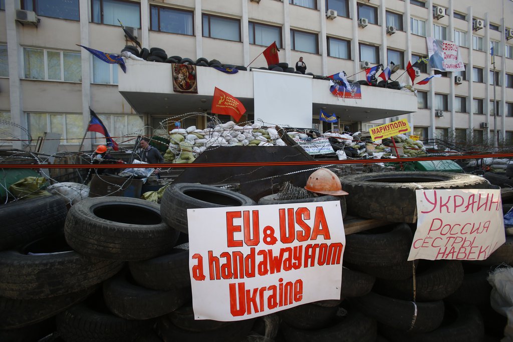 ettsk ukraineA sign reading "Ukraine and Russia are sisters forever" is attached to tires forming part of a barricade in front of the city hall as flags meant to represent the Donetsk Republic fly alongside Russian flags in Mariupol, Ukraine, Thursday, April 17, 2014. Three pro-Russian protesters were killed and 13 injured during an attempted raid overnight on a Ukrainian National Guard base in the Black Sea port of Mariupol, Ukraine's authorities said Wednesday. (AP Photo/Sergei Grits)