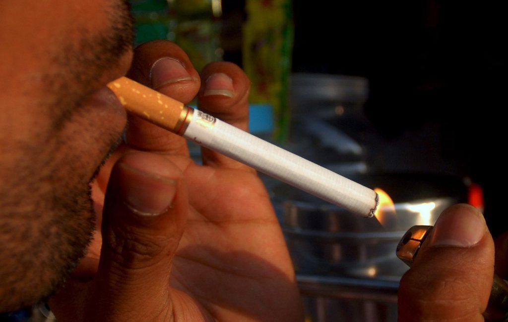 epa03171057 An Indian man lights up a cigarette at a roadside shop in Mumbai, India, 04 April 2012. According to the study report by World Tobacco Atlas, 40 per cent of cancer deaths in Indian men is due to use of tobacco, the single biggest cause of cancers in India.  EPA/DIVYAKANT SOLANKI