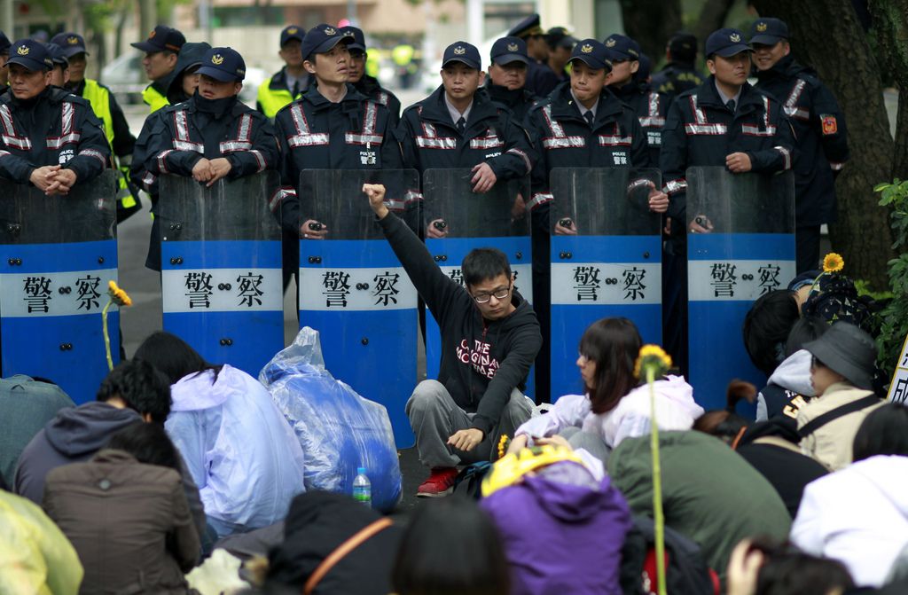 Students protesting against a China Taiwan trade pact rally in front of a wall of police outside of the occupied legislature, in Taipei, Taiwan, Thursday, March 20, 2014. Hundreds of opponents of a trade pact with China continued to demonstrate in and around Taiwan's legislature Thursday, in the most serious challenge to date to President Ma Ying-jeou's policy of moving the democratic island of 23 million people economically closer to Communist China. (AP Photo/Wally Santana)