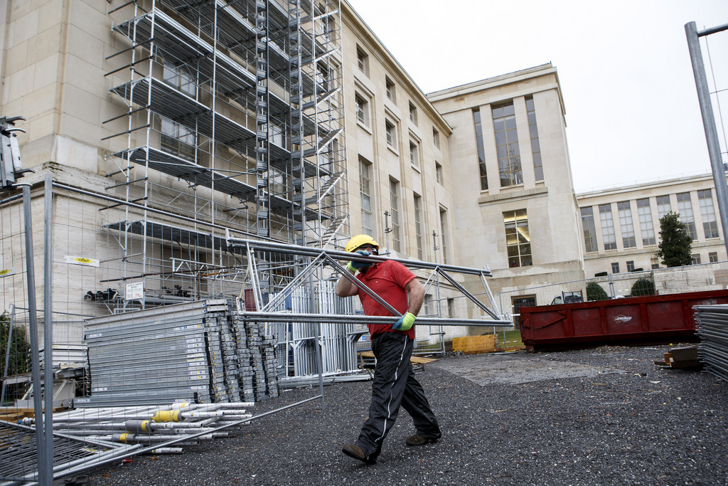 A worker carries elements of scaffolding on construction site of the Palais des Nations, at the European headquarters of the United Nations, in Geneva, Switzerland, Monday, February 10, 2014. The renovation of the Palais des Nations  has started half a year ago and it is estimated at 617 million. (KEYSTONE/Salvatore Di Nolfi)