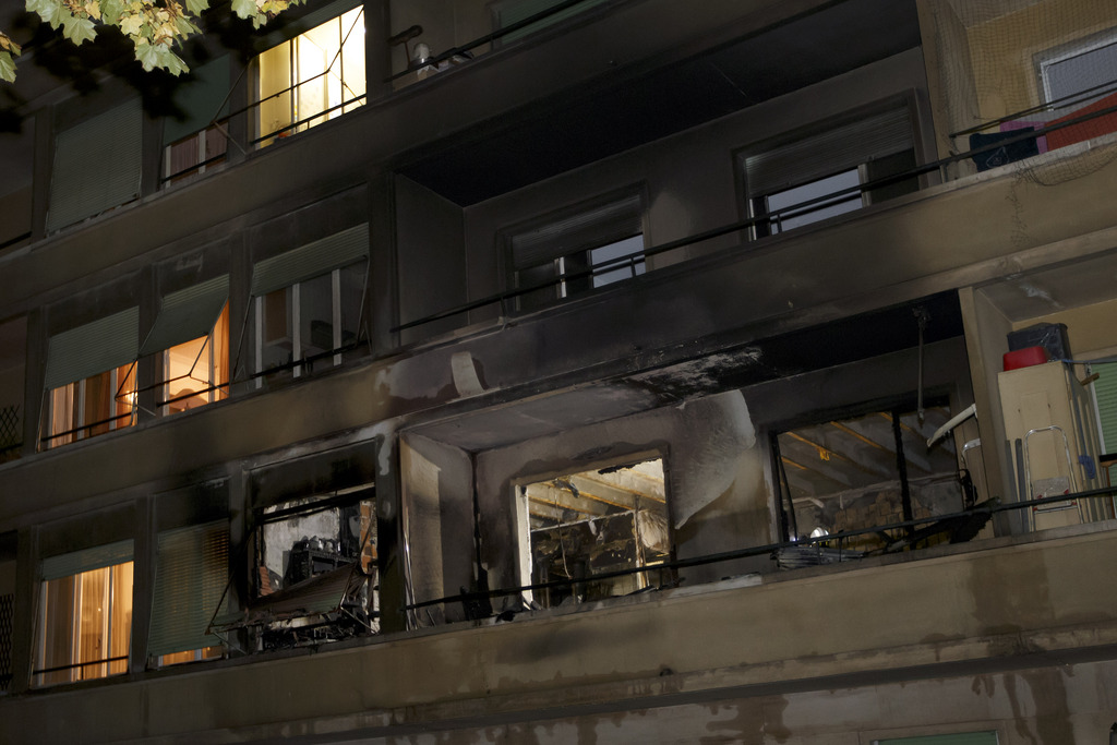 Vue de l'appartement situe au 1er etage a la rue des Contamines detruit par un incendie, ce vendredi 3 octobre 2014 a Geneve. Un incendie qui s'est declare dans la nuit de jeudi a vendredi dans un appartement du 1er etage d'un immeuble a la rue des Contamines a Geneve a fait huit blesses graves. Trois d'entre eux ont ete heliportes au Centre romand des grands brules au CHUV. Les pompiers ont du evacuer les sept etages du batiment. (KEYSTONE/Salvatore Di Nolfi)