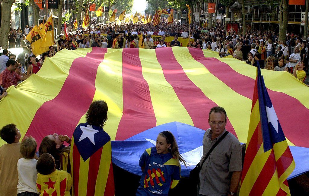 A huge flag of Catalonia is displayed during the celebration  of the autonomous feast in Catalonia region known as 'Diada Nacional de Cataluna' (National 'Diada' of Catalonia) in Barcelona, on Thursday, 11 September 2003. The slogan on the placard (at the background) reads in Catalonian 'Out the occupapying forces'. EPA PHOTO/EFE/JULIAN MARTIN///
