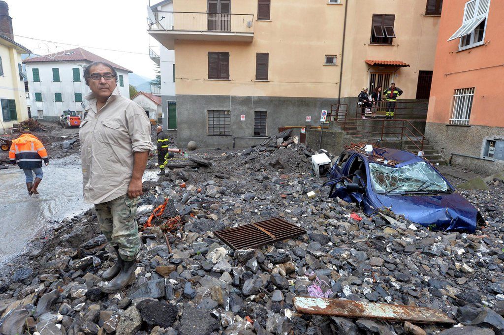 epa04441157 Volounters and citiziens work together during the clear up operation in Montoggio, near Genoa, Italy, 11 October 2014 after heavy rain hit the area. At least one person died due to  flash floods after heavy rain caused the Bisagno river, which runs through Genoa city, to swell on 10 October 2014.  Floods dragged away parked cars - including the armoured saloon used by local Cardinal Angelo Bagnasco; a train derailed, lightly injuring two passengers and the driver; about 2,000 households were left with no electricity; schools, museums and several roads were closed.  EPA/LUCA ZENNARO
