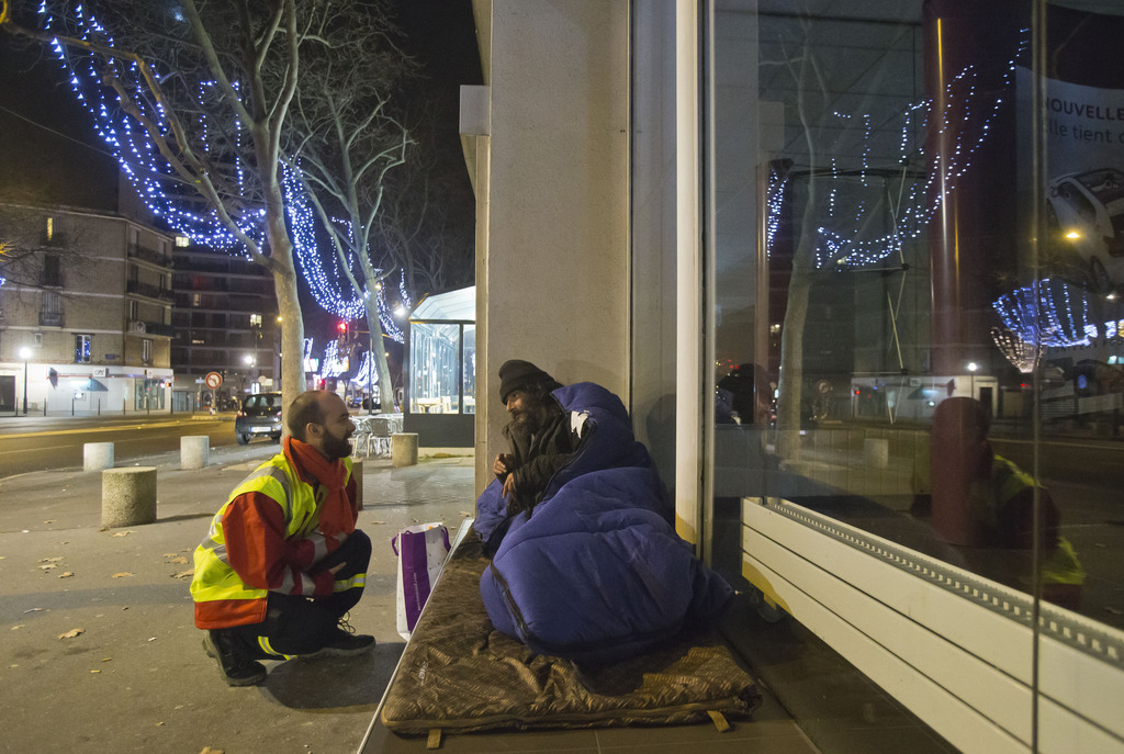A volunteer from the Malta Order Francois Xavier Kuhn, left, speaks to a homeless man in Boulogne-Billancourt, outside Paris, Monday, Dec. 29, 2014. Snow and icy weather swept through parts of Europe on the weekend, stranding drivers overnight and leaving thousands of homes without power in Britain. Snow also covered parts of Switzerland and southwestern Germany, and more than 20 centimeters (nearly eight inches) of snow has fallen in higher parts of Germany's Black Forest. (AP Photo/Michel Euler)