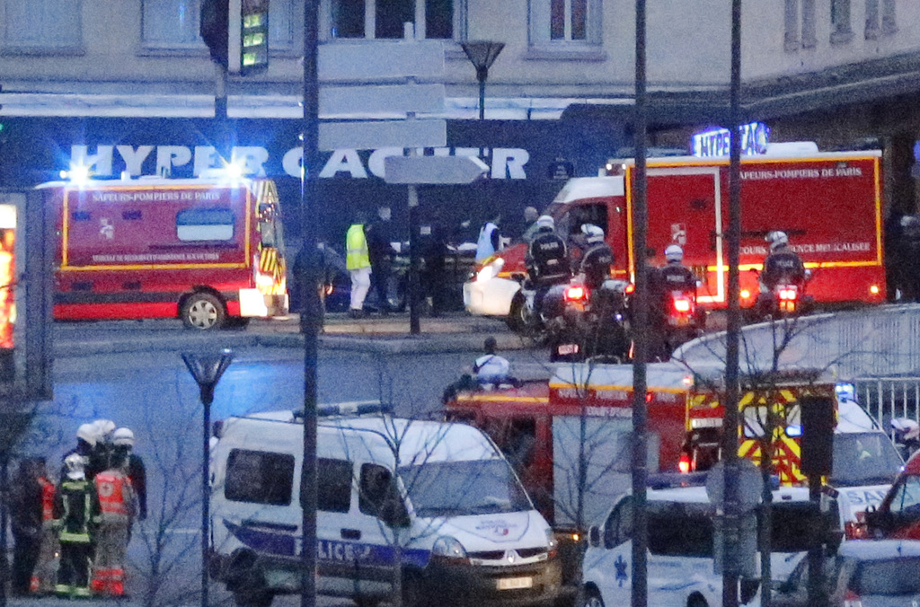 Rescue workers enter after police forces stormed the kosher store where a gunman held several hostages, in Paris, Friday Jan. 9, 2015. The assault came moments after a similar raid on the building where two brothers suspected in the Charlie Hebdo newspaper massacre were cornered. (AP Photo/Francois Mori)