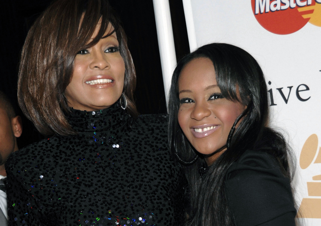 FILE - In this Feb. 12, 2011, file photo, singer Whitney Houston, left, and daughter Bobbi Kristina Brown arrive at an event in Beverly Hills, Calif.  The daughter of late singer and entertainer Whitney Houston was found Saturday, Jan. 31, 2015, unresponsive in a bathtub by her husband and a friend and taken to an Atlanta-area hospital. The incident remains under investigation.   (AP Photo/Dan Steinberg, File)