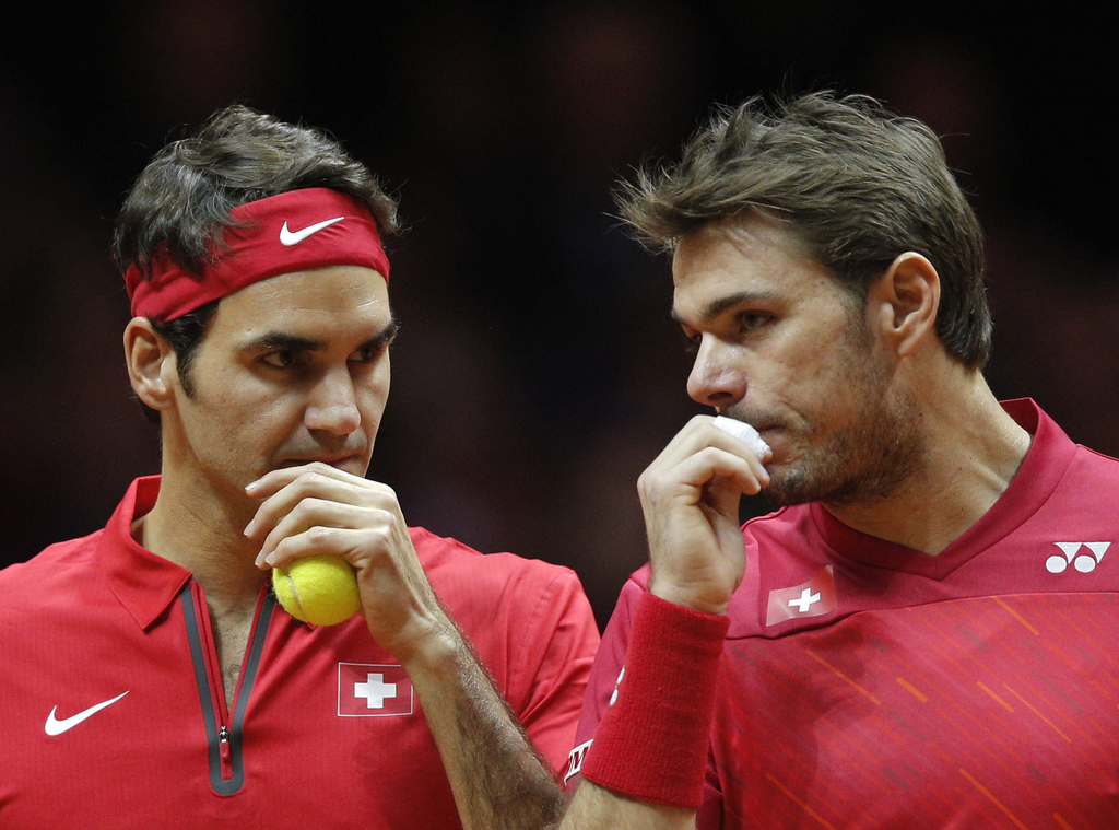 Switzerland's Roger Federer, left, and Stanislas "Stan" Wawrinka chat while playing France's Julien Benneteau and Richard Gasquet during their doubles match for the Davis Cup final in Lille, northern France, Saturday, Nov.22, 2014. (AP Photo/Christophe Ena)