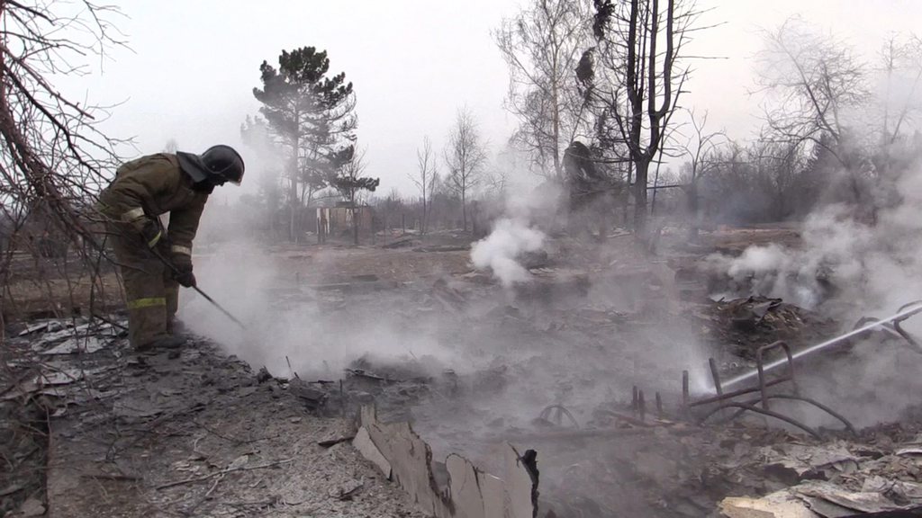 epa04703283 A handout picture dated 13 April 2015 and and released by the Russian Emergency Ministry press service shows a firefighter extinguishing a fire in the republic of Khakassia in the southeastern Siberia, Russia. The Khakassia devastating fires killed 23 people and destroyed over 1,285 buildings.  EPA/RUSSIAN EMERGENCY MINISTRY / HO HANDOUT EDITORIAL USE ONLY/NO SALES