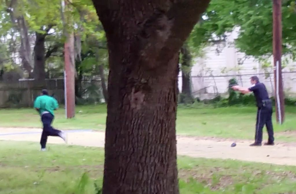 In this April 4, 2015, frame from video provided by Attorney L. Chris Stewart representing the family of Walter Lamer Scott, Scott runs away from city patrolman Michael Thomas Slager, right, in North Charleston, S.C. Slager was charged with murder on Tuesday, April 7, hours after law enforcement officials viewed the dramatic video that appears to show him shooting a fleeing Scott several times in the back. (AP Photo/Courtesy of L. Chris Stewart)