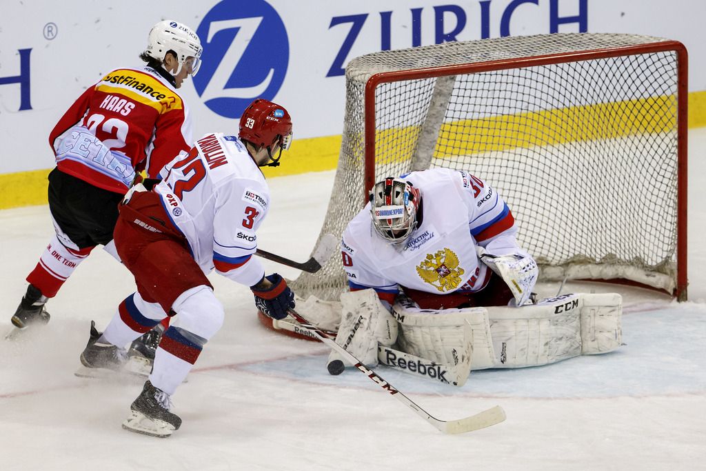 Russia's goaltender Konstantin Barulin, right, saves a puck in front of Switzerland's Haas Gaetan, left, and Russia's Albert Yarulin, center, during friendly ice hockey game between Switzerland and Russia, at the ice stadium Les Vernets, in Geneva, Switzerland, Wednesday, April 8, 2015. (KEYSTONE/Salvatore Di Nolfi)