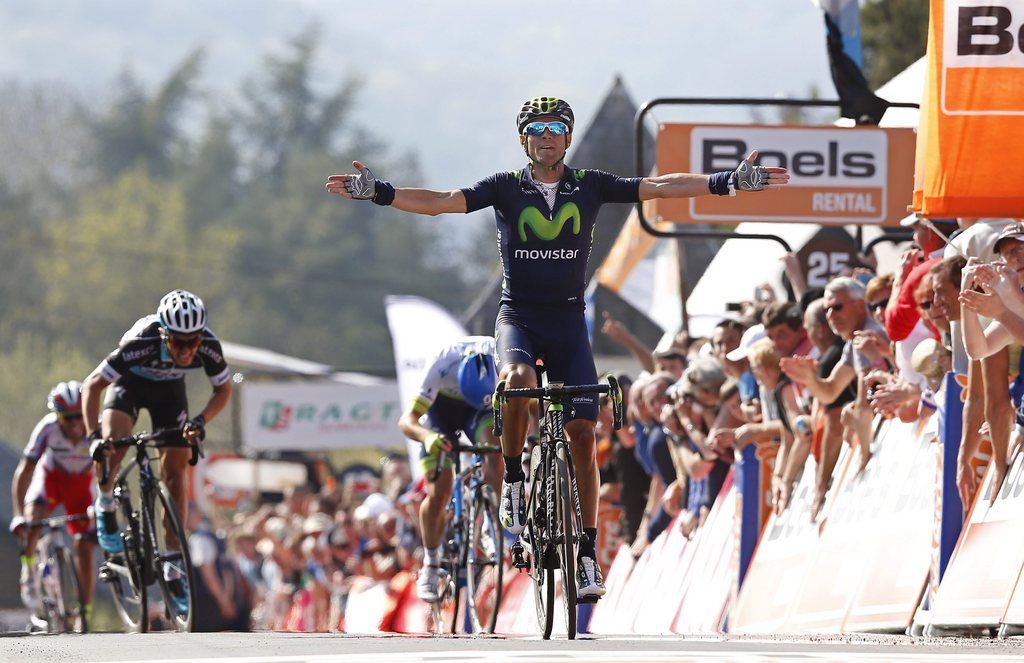 epa04716275 Spanish rider Alejandro Valverde (C) of Team Movistar celebrates while crossing the finish line to win the Fleche Wallonne cycling race in Huy, Belgium, 22 April 2015.  EPA/JULIEN WARNAND