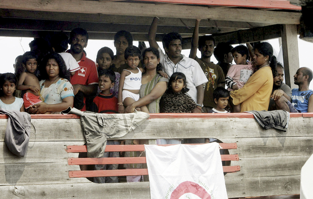 In this October 14, 2009, file photo, Sri Lankan migrants bound for Australia remain on board their boat docked at a port in Cilegon, Banten province, Indonesia, after they were intercepted by the Indonesian navy. Two recent shipwrecks in the Mediterranean Sea believed to have taken the lives of as many as 1,300 asylum seekers and migrants has highlighted the escalating flow of people fleeing persecution, war and economic difficulties in their homelands. (AP Photo/Irwin Fedriansyah, File)
