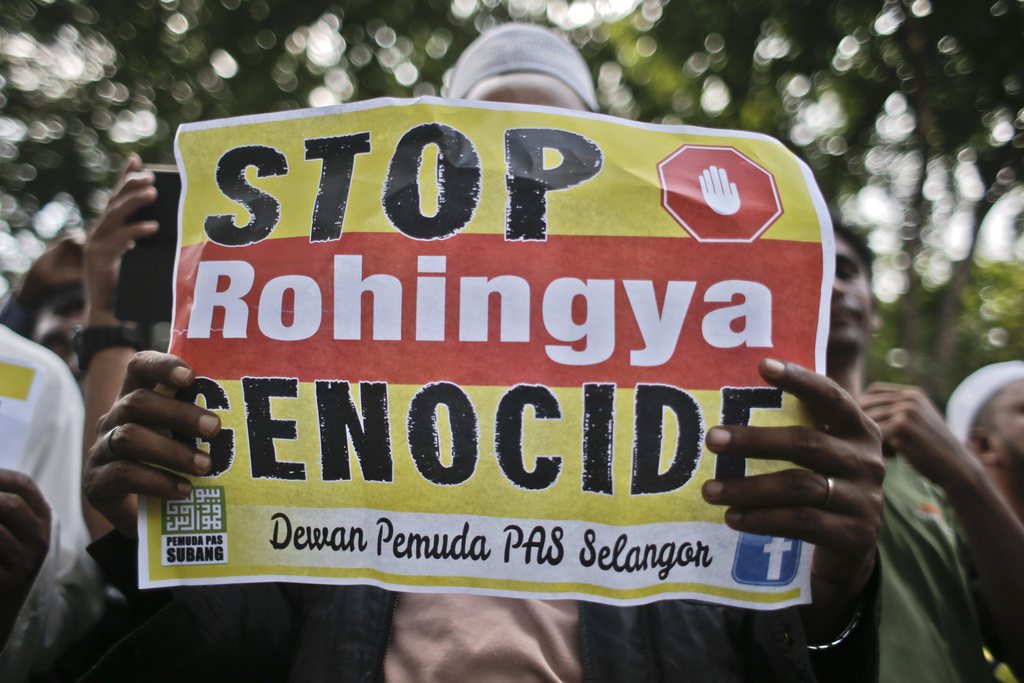 epa04759509 A man holds a placard reading 'Stop Rohingya Genocide' during a demonstration outside the Myanmar Embassy to demand an end to discrimination against the Rohingya minority group in Kuala Lumpur, Malaysia, 21 May 2015. Community Action for Rohingya called for Myanmar's ambassador to Malaysia and embassy staff to leave the country over the migrant crisis. Meanwhile, Malaysia ordered its navy to conduct search-and-rescue operations to recover Rohingya migrant boats and bring them ashore.  EPA/FAZRY ISMAIL