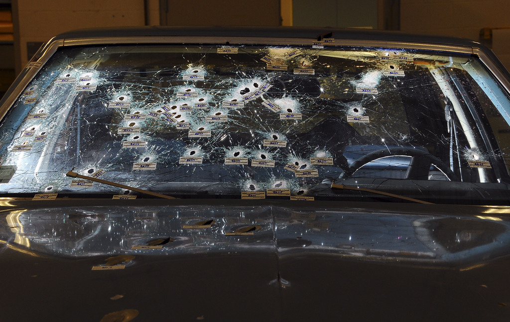 FILE - In this Nov. 30, 2012 file forensics photo released by the Office of the Ohio Attorney General, bullet holes are visible on the windshield and hood of a Chevy Malibu peppered by gunshots after a high-speed chase that ended in the deaths of two unarmed suspects.   Michael Brelo, a police officer charged in the shooting deaths of Timothy Russell and Malissa Williams, two unarmed suspects during a 137-shot barrage of gunfire, was acquitted, Saturday, May 23, 2015.  (Office of the Ohio Attorney General via AP, File)