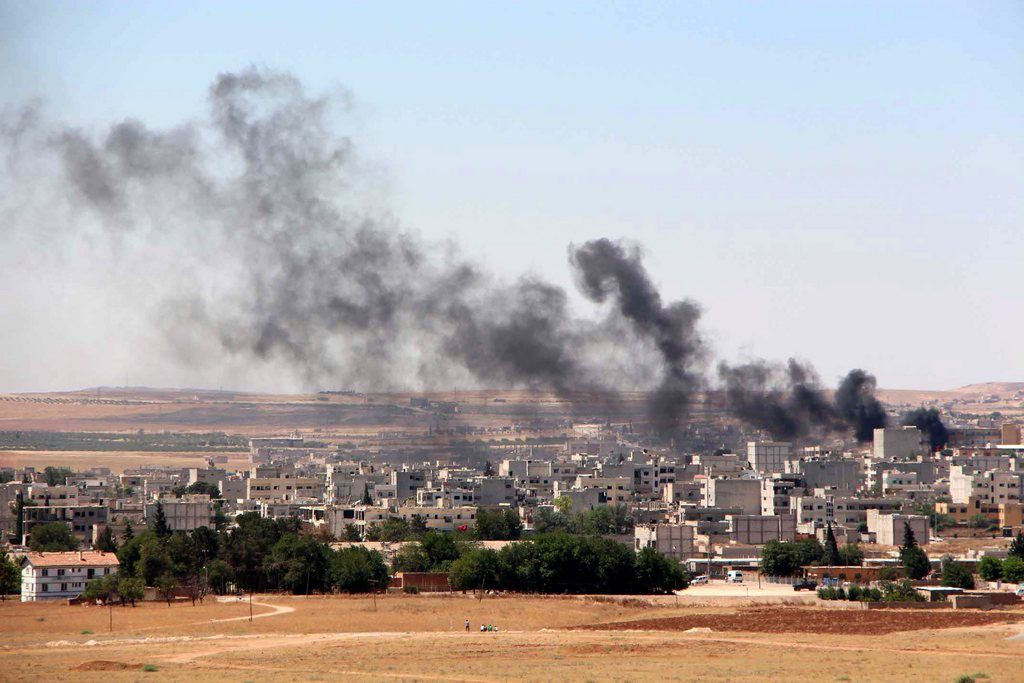 epa04817874 A picture taken from the Turkish side of the border shows smoke rising after renewed attack by Islamic State in Kobane, Syria, 25 June 2015. According to media reports, Islamic State jihadists once again advanced into the town of Kobane in northern Syria after being driven from the area by Kurdish forces at the end of January. There was heavy fighting in several districts between Kurdish troops and the extremists during the night. Sanliurfa governorate said that 41 victims of the fighting have been brought to hospital in the Turkish city of Suruc, and one of them has died.  EPA/STR