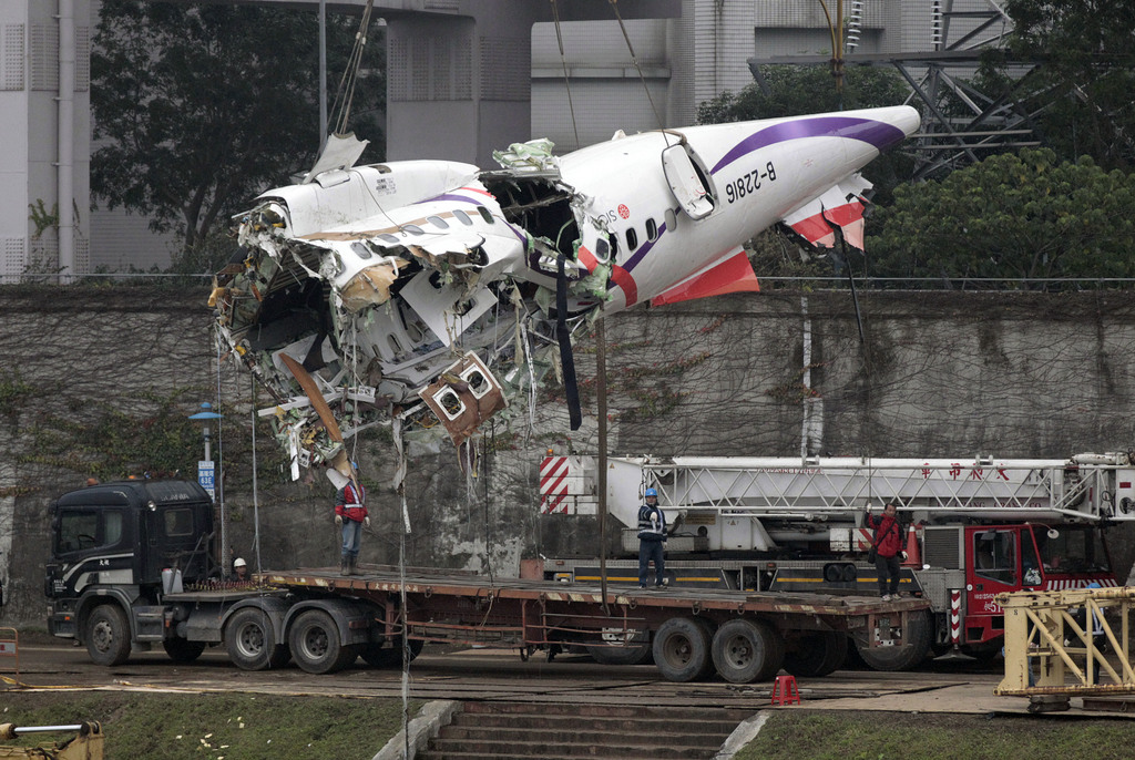 The main fuselage from TransAsia Airways Flight 235 is hoisted away in Taipei, Taiwan, Thursday, Feb. 5, 2015. The commercial plane crash with 58 people aboard clipped a bridge shortly after takeoff and crashed into a river in the island's capital of Taipei on Wednesday morning. (AP Photo/Wally Santana)