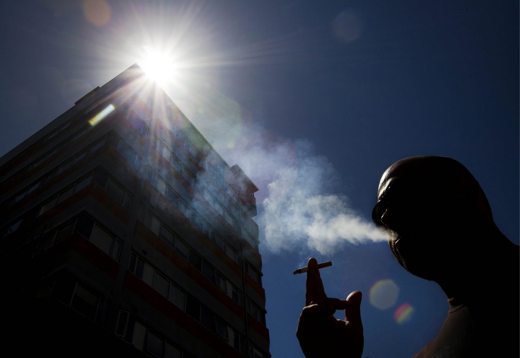 In this Jan. 18, 2012 photo, a smoker puffs on a cigarette in the central business district in Auckland, New Zealand. New Zealand's government on Thursday, May 24, 2012, squeezed smokers more than ever by announcing a 40 percent hike in tobacco taxes over the next four years. Officials hope higher taxes and new restrictions will bring the nation of 4.4 million closer to a recent pledge to snuff out the habit entirely by 2025. (AP Photo/New Zealand Herald, Brett Phibbs) New Zealand Out, Australia Out