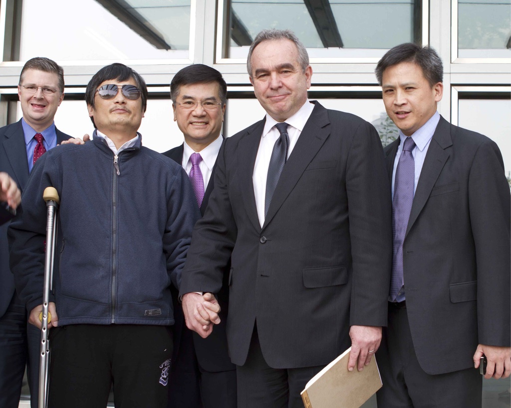 L'avocat dissident Chen Guangcheng (gauche), tient la main de l'envoyé américain chargé des affaires de l'Asie Pacifique Kurt Campbell. L'ambassadeur Gary Locke est derrière.