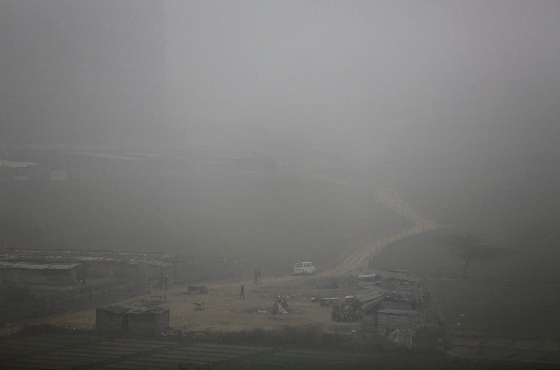 In this Saturday, Dec. 12, 2015 file photo, farmers walk near fields during a foggy and polluted morning in the outskirts of New Delhi, India. When New Delhis winter air grew so bad that a high court warned that it seems like we are living in a gas chamber, the citys top official declared that cars would be restricted starting Jan. 1,  with odd and even license plates taking turns on the roads. But police officials quickly announced they hadnt been consulted, and said theyd have trouble enforcing the rule.  (AP Photo/Altaf Qadri, File) The Week That Was In Asia Photo Gallery