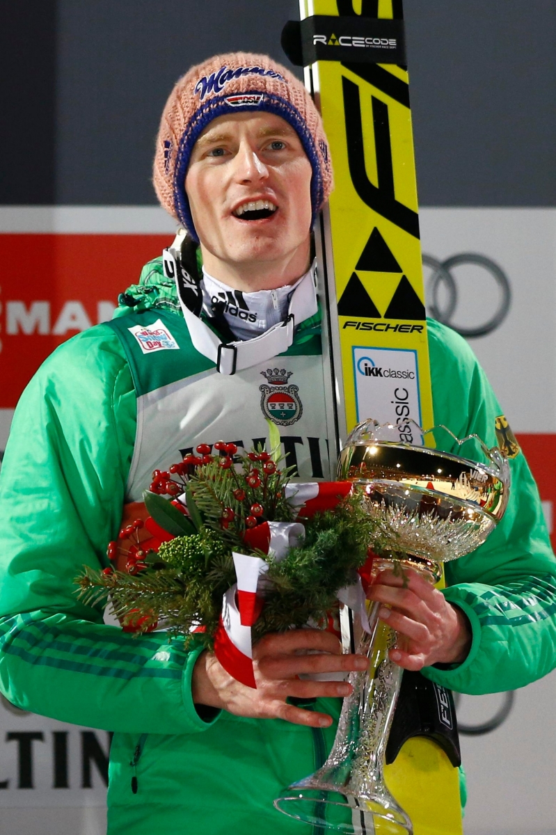 Germany's Severin Freund celebrates on the podium after winning the first stage of the 64. four hills ski jumping tournament in Oberstdorf, Germany,  Tuesday, Dec. 29, 2015. (AP Photo/Matthias Schrader) Germany Ski Jumping Four Hills