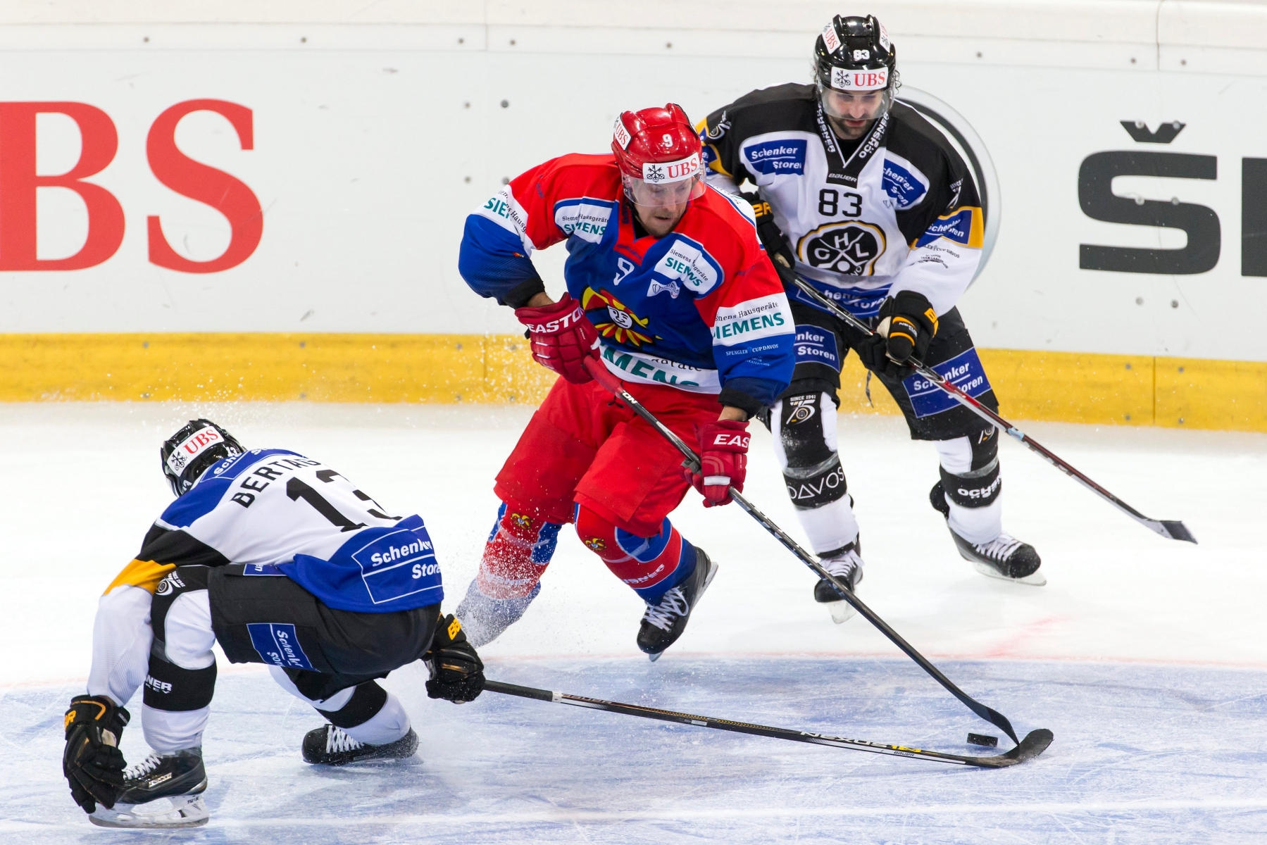 Helsinki's Niklas Hagmann, middle, fight for the puck with Lugano's Alessio Bertaggia, left and Dan Spang, right, during the game between Switzerland's HC Lugano and Finland's Jokerit Helsinki at the 89th Spengler Cup ice hockey tournament in Davos, Switzerland, Monday, December 28, 2015. (KEYSTONE/Pascal Muller) EISHOCKEY SPENGLER CUP 2015 LUGANO HELSINKI