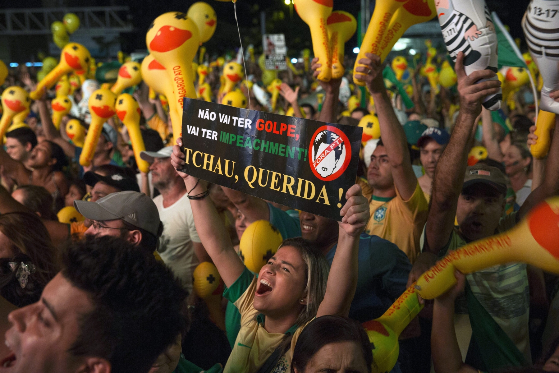 epa05264836 Hundreds of people watch a screen displaying the Chamber of Deputies's discussion, at Paulista Avenue in Sao Paulo, Brazil, 17 April 2016. Banner reading 'You will have not a golpe. You will be impeached. Goodbye Dear!' Thousands of people took to the streets of several Brazilian cities as the Chamber of Deputies started voting to decide if the Senate should take up the process of impeaching President Dilma Rousseff. Should the lower house vote in favor of the impeachment process, the Senate will have the last word on the eventual opening of the political trial. Of the 27 political parties represented in the lower house, only seven have spoken in favor of the president and cast their vote against an eventual impeachment trial.  EPA/SEBASTIAO MOREIRA BRAZIL CRISIS