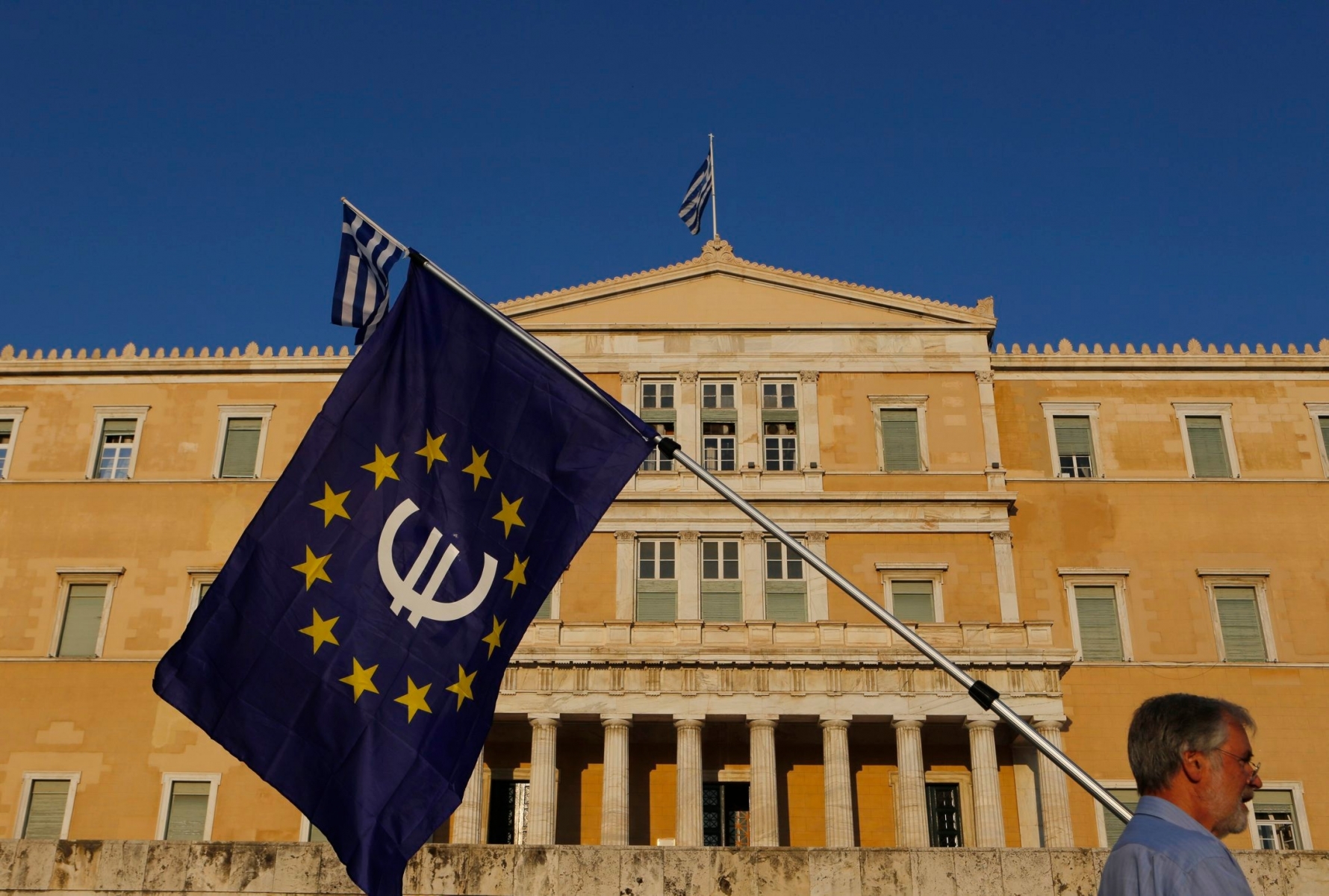 A pro-Euro demonstrator holds a European Union flag in front of Greek Parliament during a rally at Syntagma square in Athens, Thursday, July 9, 2015. Hopes that Greece can get a rescue deal that will prevent a catastrophic exit from the euro rose on Thursday, after key creditors said they were open to discussing how to ease the country's debt load, a long-time sticking point in their talks. (AP Photo/Petros Karadjias) Greece Bailout