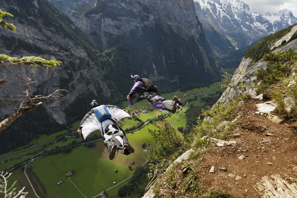 Two basejumpers fall after leaping from the exit point High Nose (550 meters) in the valley of Lauterbrunnen, Switzerland, pictured on august 14, 2011. Since they are wearing wingsuits, their free-fall-time is extended up to 40 seconds. Without wingsuit, the free fall lasts only a few seconds.  (KEYSTONE/Gaetan Bally)