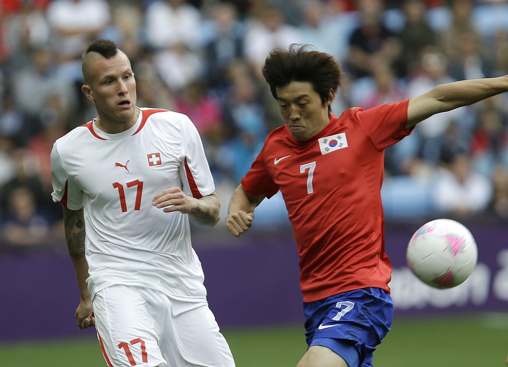 South Korea's Kim Bok-yung, right, battles for the ball against Switzerland's Michel Morganella during their group B men's soccer match between South Korea and Switzerland at the London 2012 Summer Olympics, in Coventry, England, Sunday, July 29, 2012. (AP Photo/Hussein Malla)