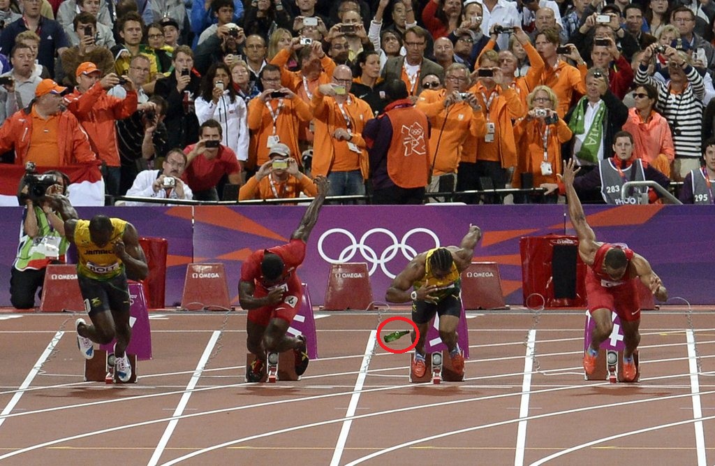 La bouteille lancée depuis la foule repose sur la piste de la finale du 100 m messieurs des JO de Londres. De g. à d., Usain Bolt, Justin Gatlin, Yohan Blake et Tyson Gay au départ de la course.