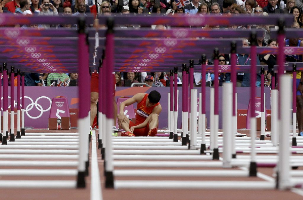 Le Chinois Liu Xiang à terre après sa chute lors des séries du 110 m haies des JO de Londres.