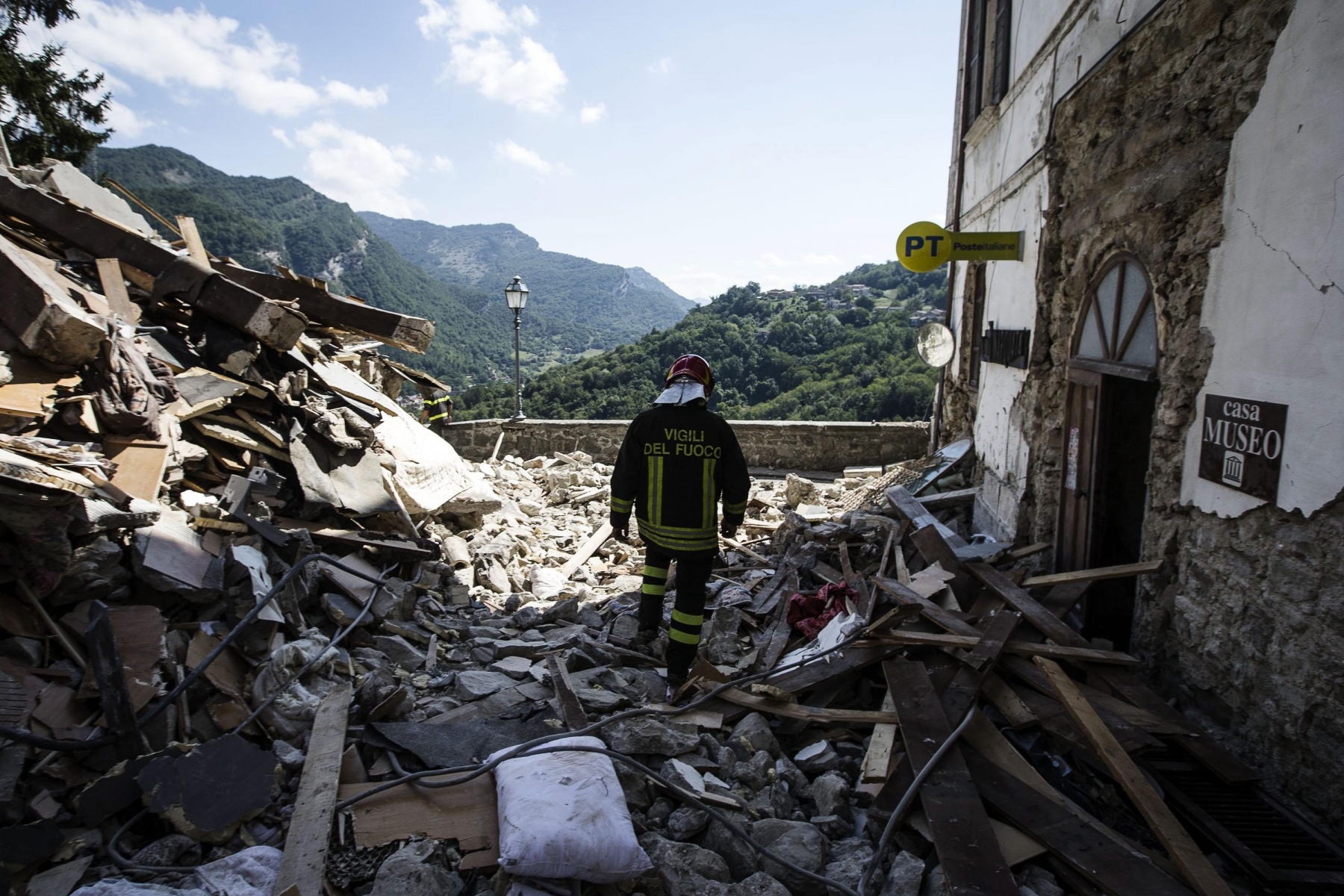 epa05509566 A fireman at work among the rubble of collapsed houses in Arquata, central Italy, 25 August 2016. The provisional death toll from 24 August's earthquake in central Italy has risen to 247, the civil protection agency said on 25 August.  EPA/ANGELO CARCONI ITALY EARTHQUAKE