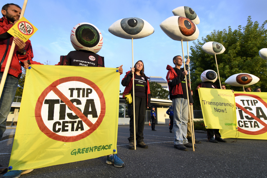 Greenpeace dénonce les négociations sur le TiSA avec des yeux surdimensionnés symbolisant la vigilance de la société par "un oeil public" et le slogan "Ne bradez pas notre planète".