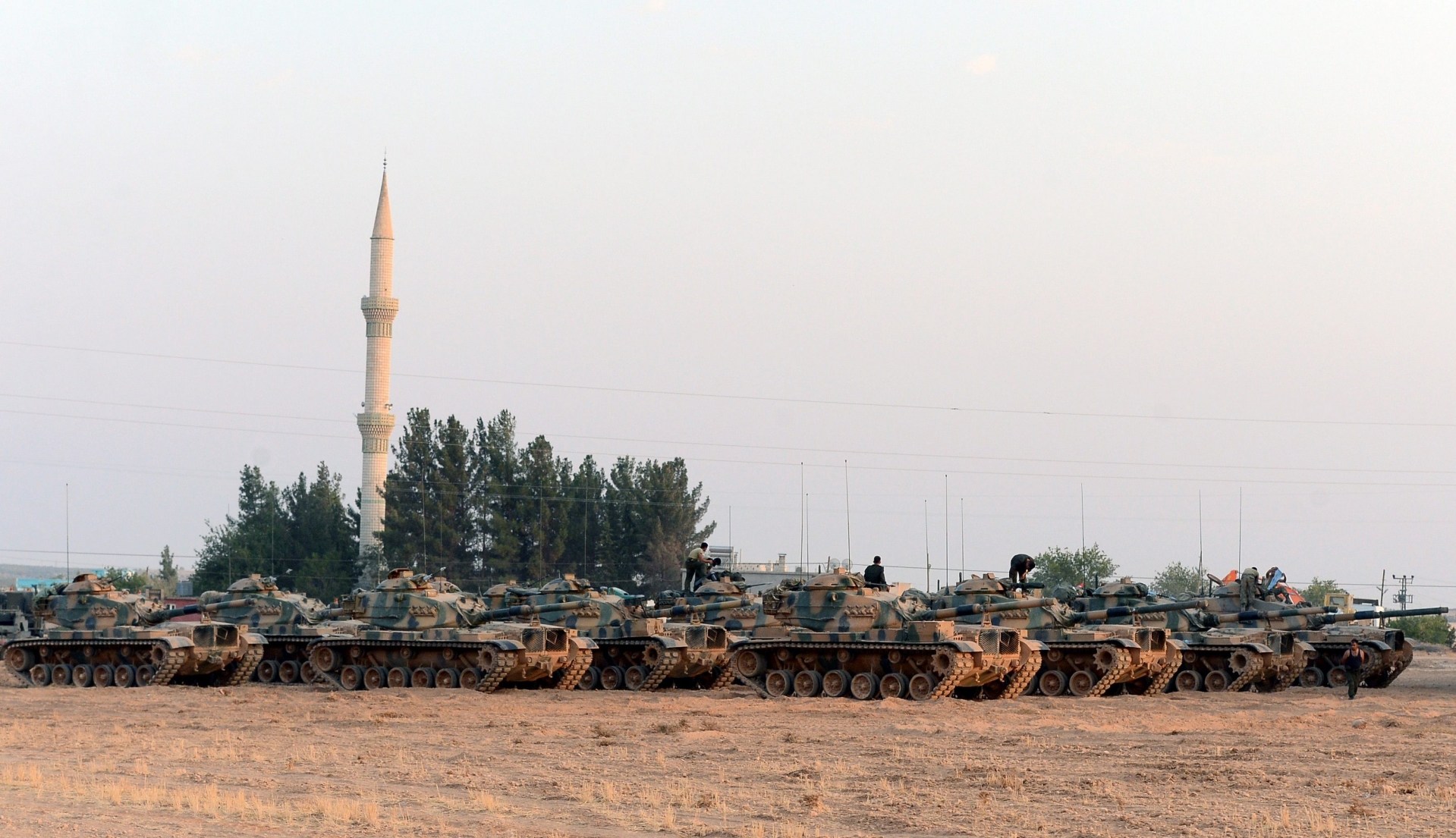 Turkish tanks stationed near the Syrian border, in Karkamis, Turkey, Saturday, Aug. 27, 2016. Turkey on Wednesday sent tanks across the border to help Syrian rebels retake the key Islamic State-held town of Jarablus and to contain the expansion of Syria's Kurds in an area bordering Turkey.(Ismail Coskun, IHA via AP) Turkey Syria
