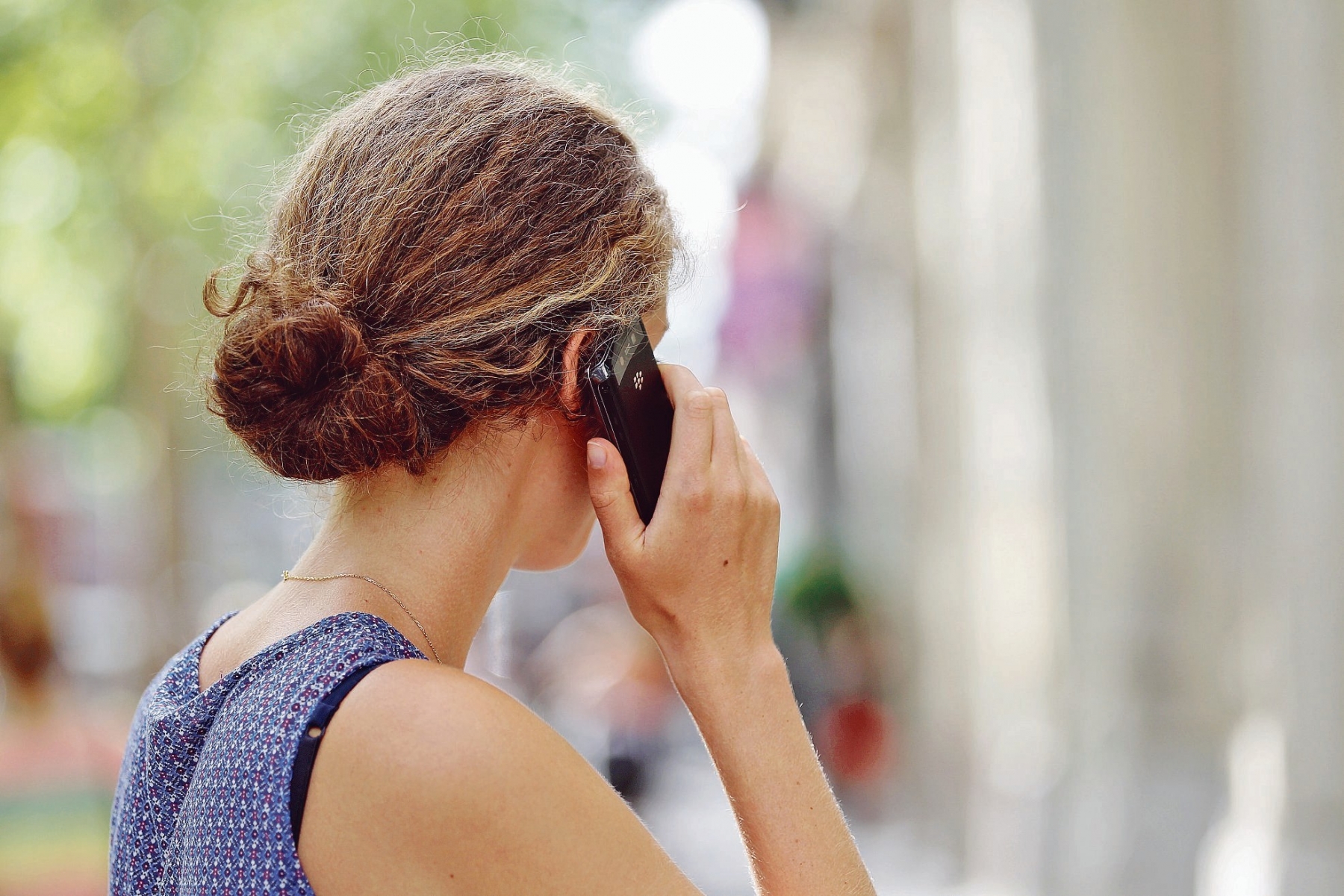 Une jeune femme utilise son télépone portable dans la rue. 107511