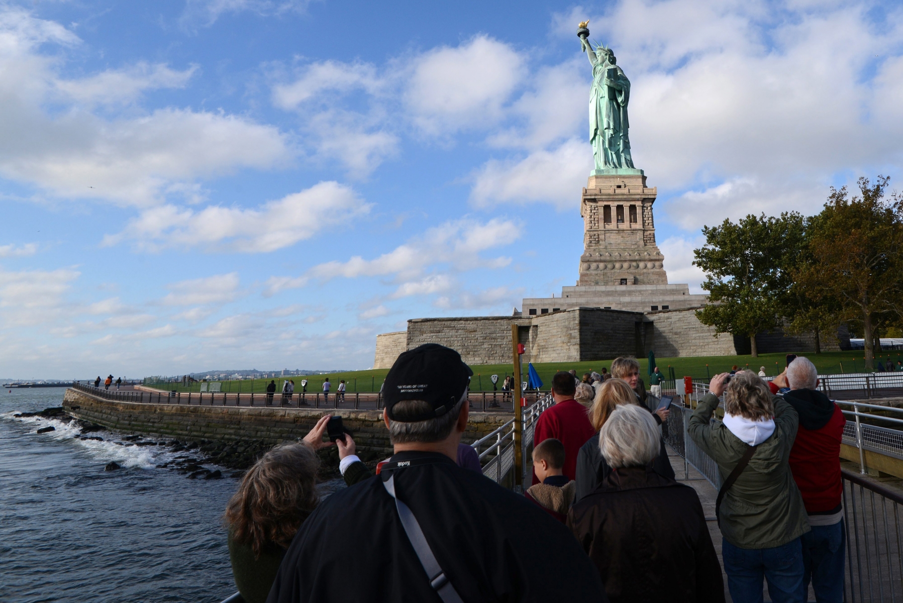 epa03908657 Tourists take pictures of the reopened Statue of Liberty, on Liberty Island in New York City, New York, USA, 13 October 2013. Four US states will pay the federal government to keep their major tourism attractions open for visitors. Arizona, South Dakota, Utah and New York state have agreed to pay the National Park Service to reopen locations that have been closed since the partial US government shutdown commenced on 01 October.  EPA/PETER FOLEY USA STATUE OF LIBERTY REOPENS